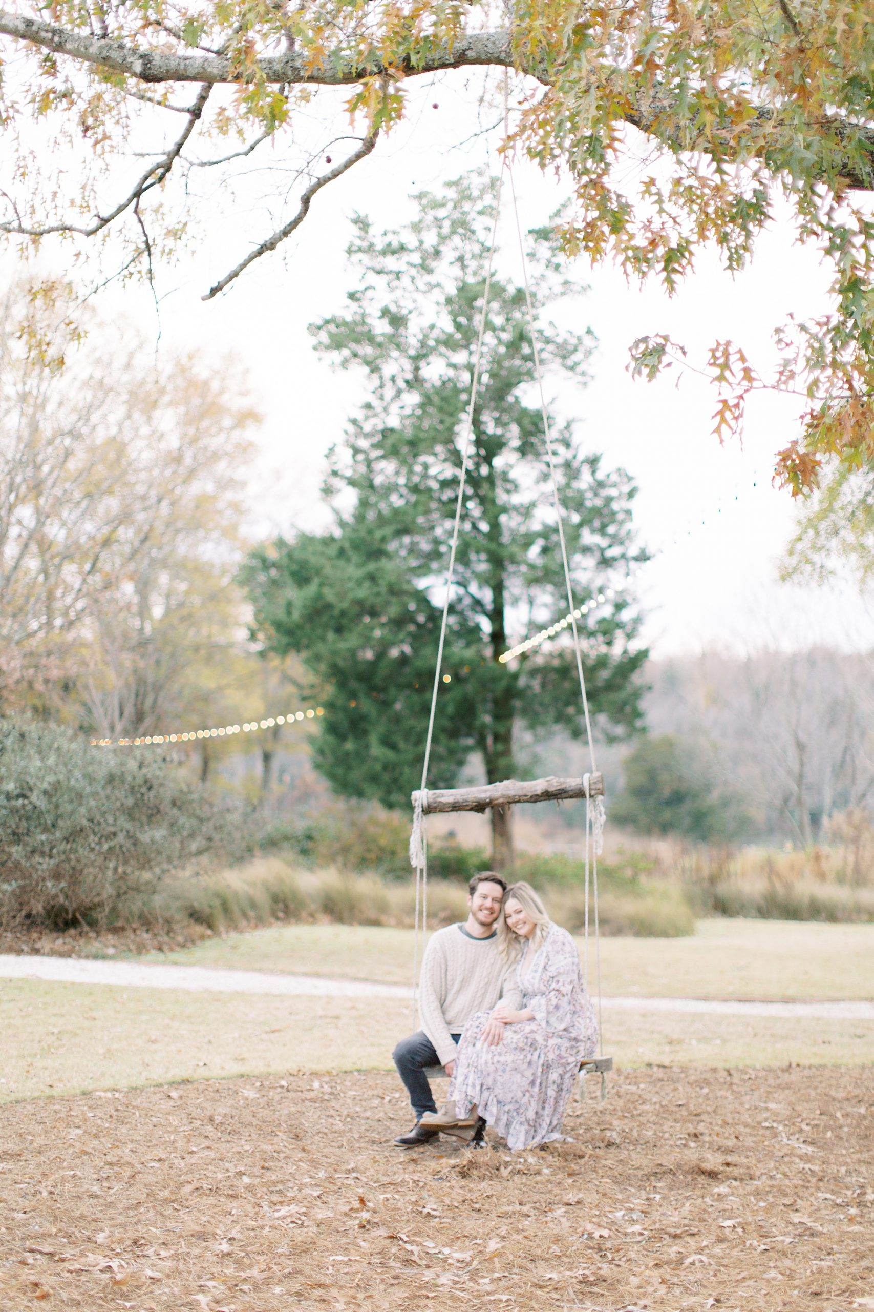 engaged couple sits on wooden swing in Lancaster SC