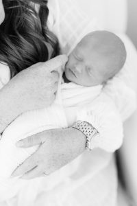 mom holds newborn baby boy during lifestyle photos at home with Charlotte newborn photographer