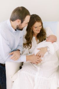 parents hold newborn baby boy during nursery photos