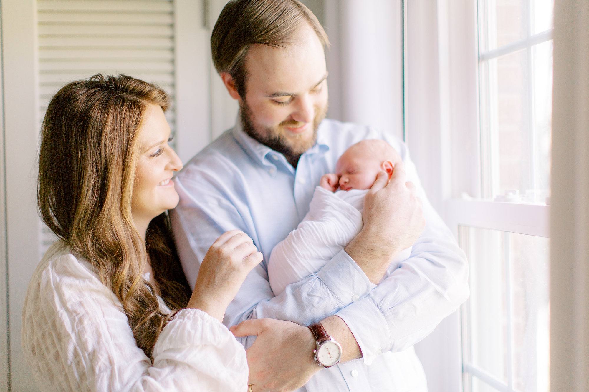 parents hold little boy during lifestyle photos at home