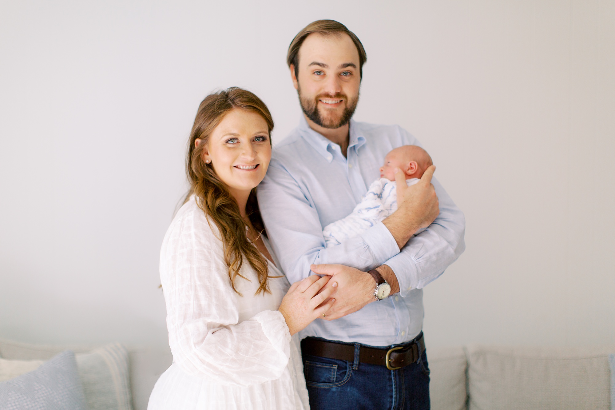 new parents hold baby boy at home