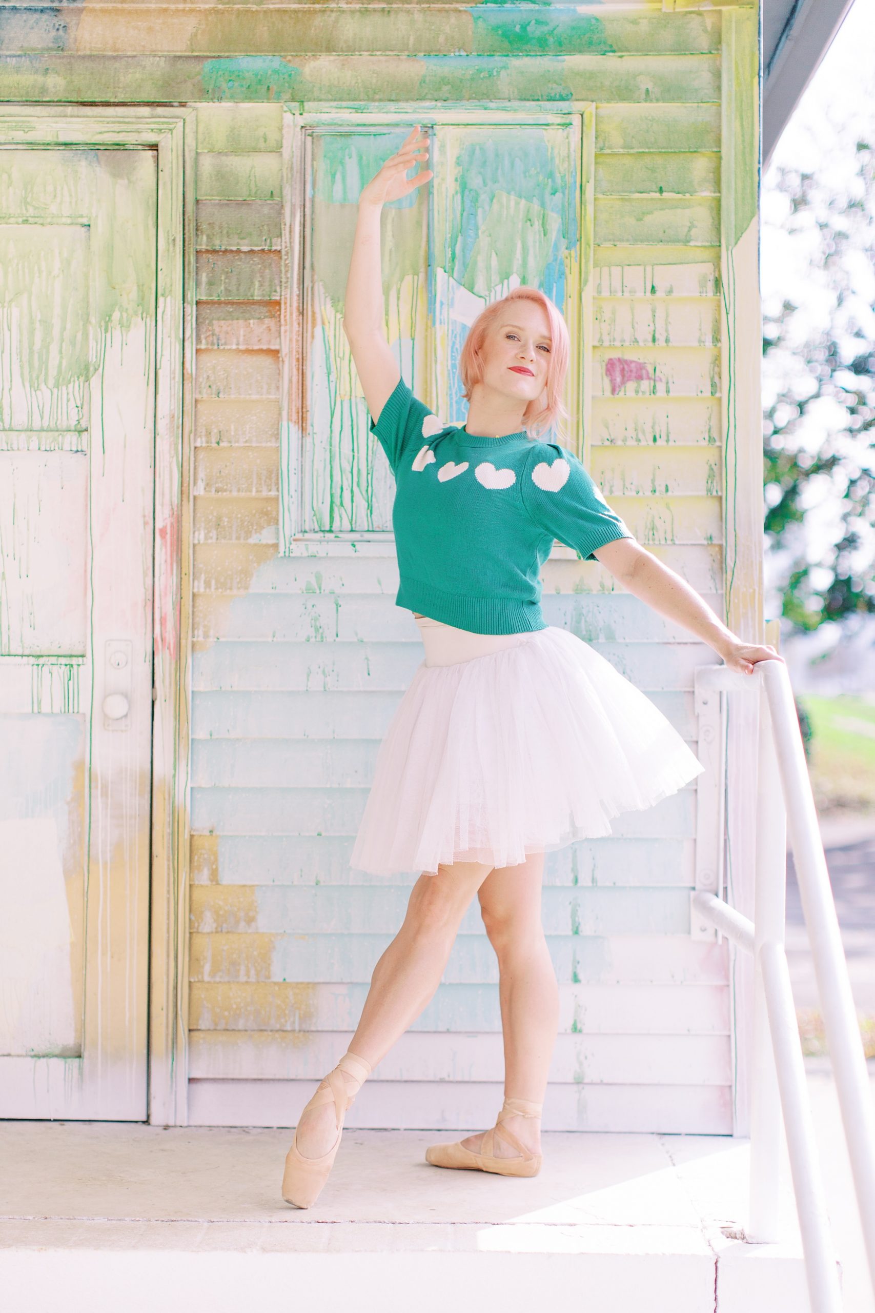 ballerina poses at top of stairs in pink tutu
