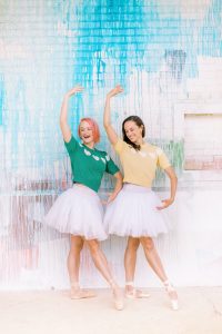 dancers pose together in front of colorful wall in Uptown Charlotte