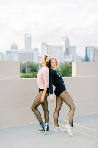 two dancers pose on rooftop back to back during Uptown Charlotte Branding Session