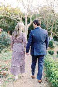 married couple holds hands walking through McGill Rose Garden