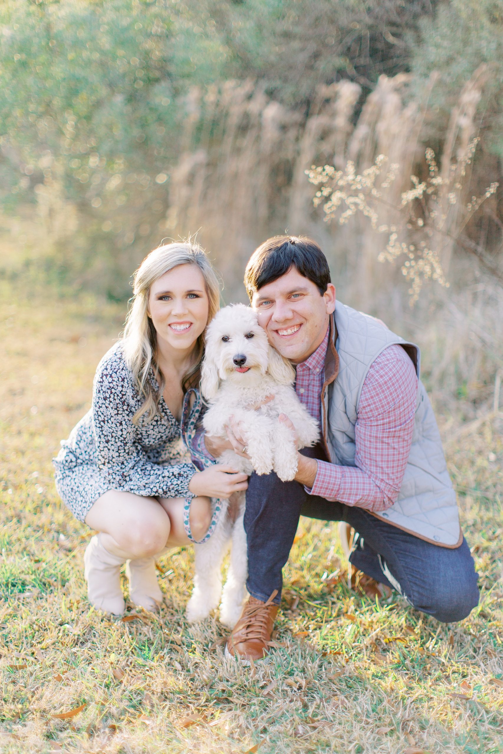 husband and wife hold dog up during anniversary session