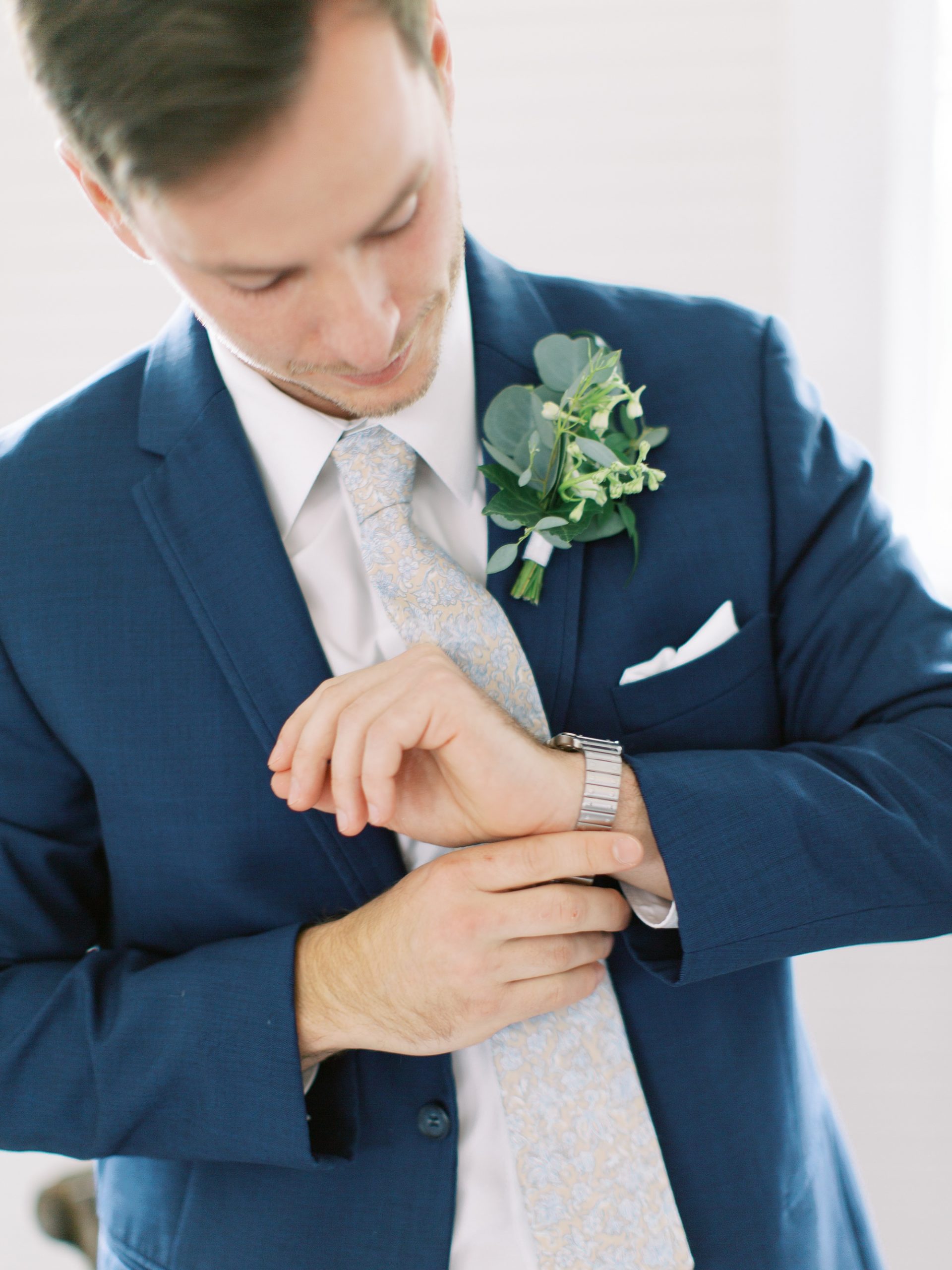groom adjusts cufflinks before SC wedding day