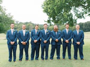groom and groomsmen in navy suits pose before SC wedding