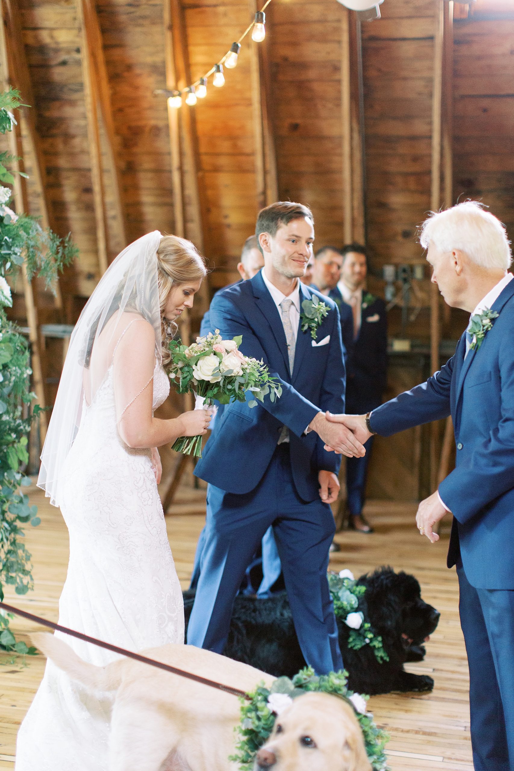 father shakes hand with groom during wedding ceremony