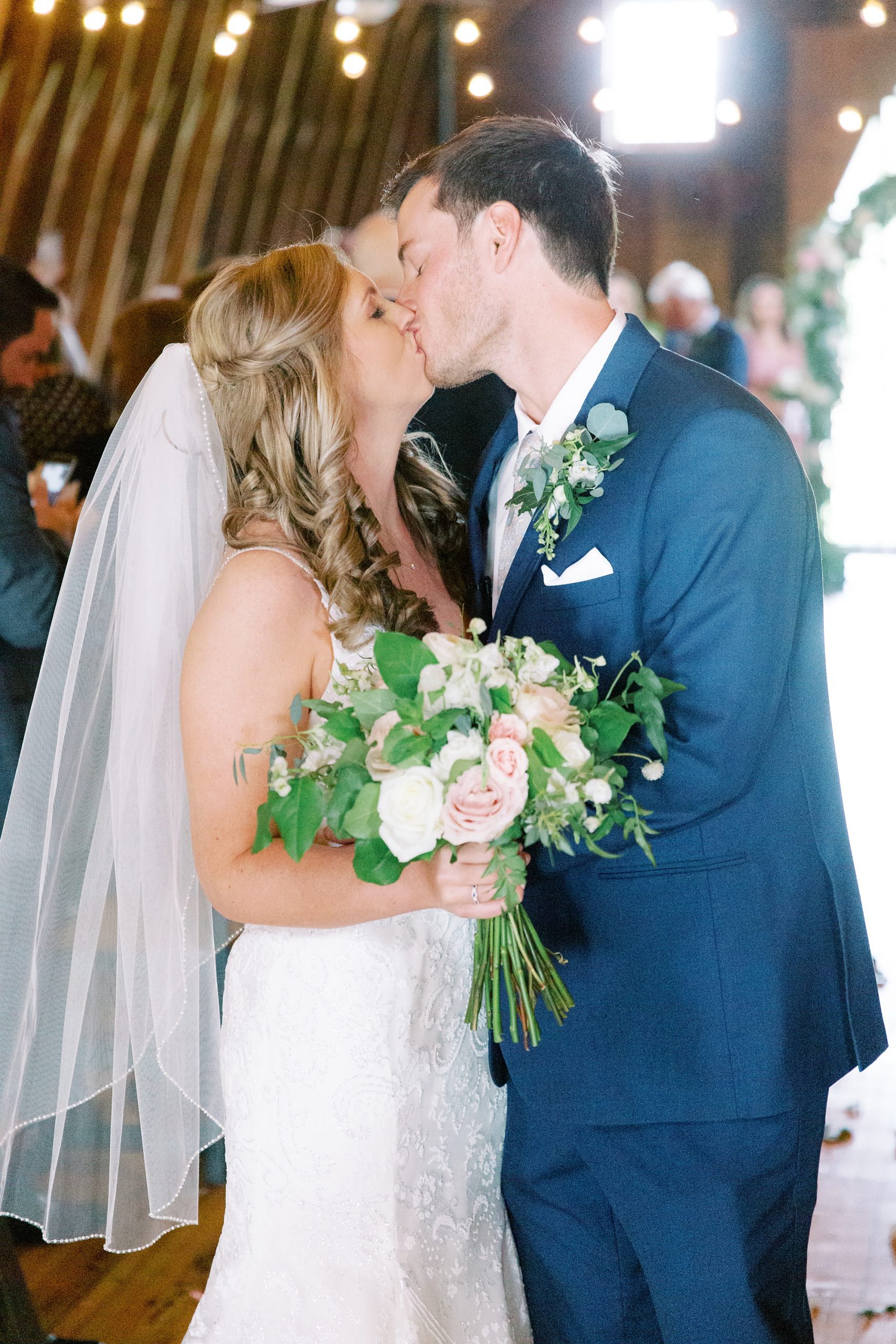 newlyweds kiss at end of aisle at The Dairy Barn