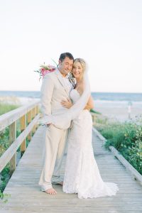 bride and groom hug on walkway at Sullivan's Island