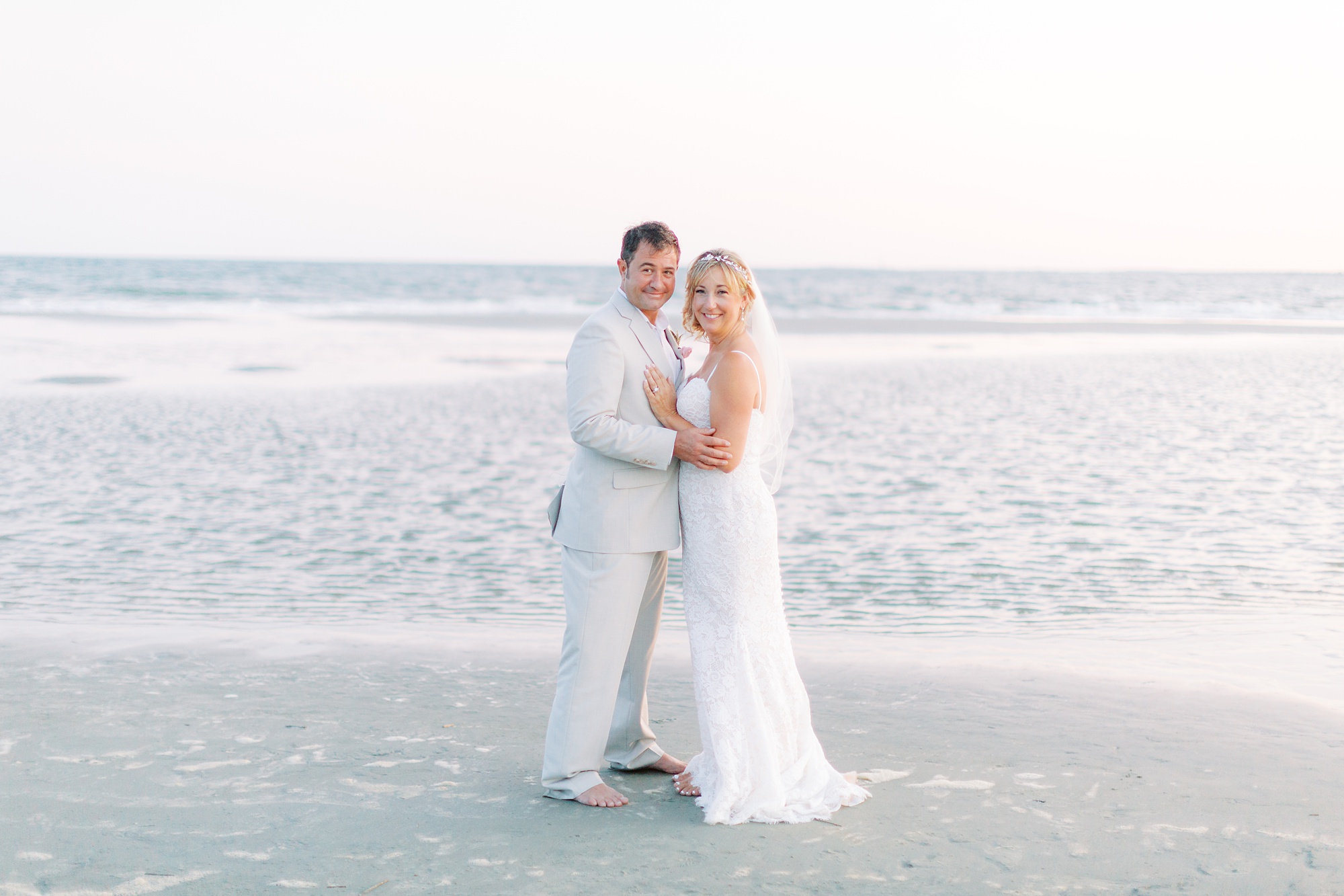 bride and groom pose by water in Charleston