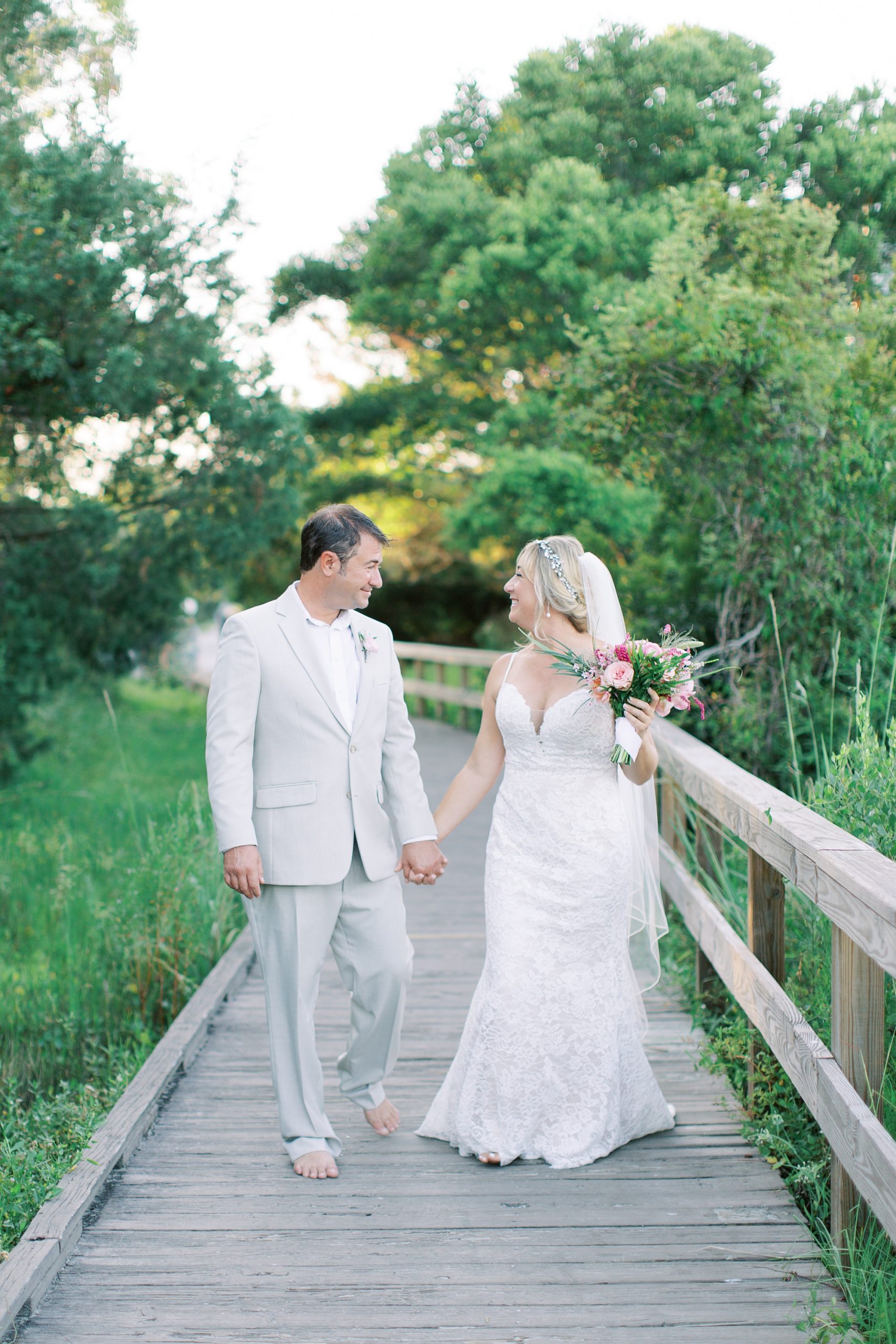 bride and groom walk on Sullivan's Island walkway