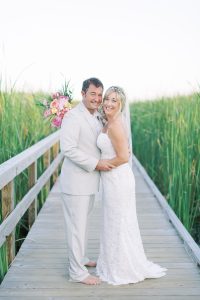 newlyweds pose on walkway on Sullivan's Island