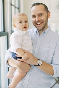dad and son laugh together during NC photos at home