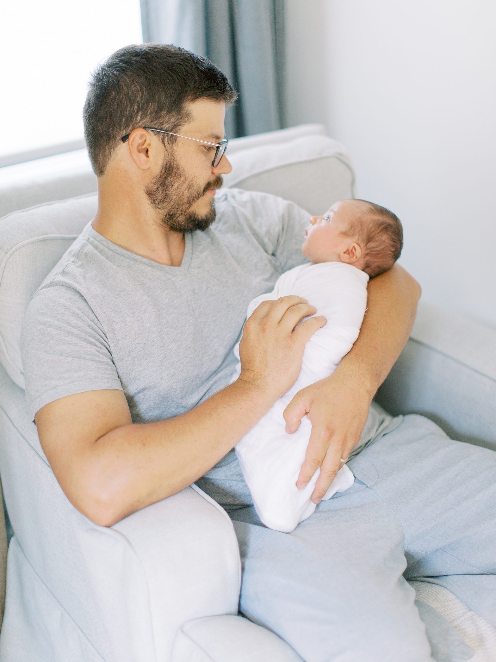 dad holds baby boy rocking during Charlotte newborn session