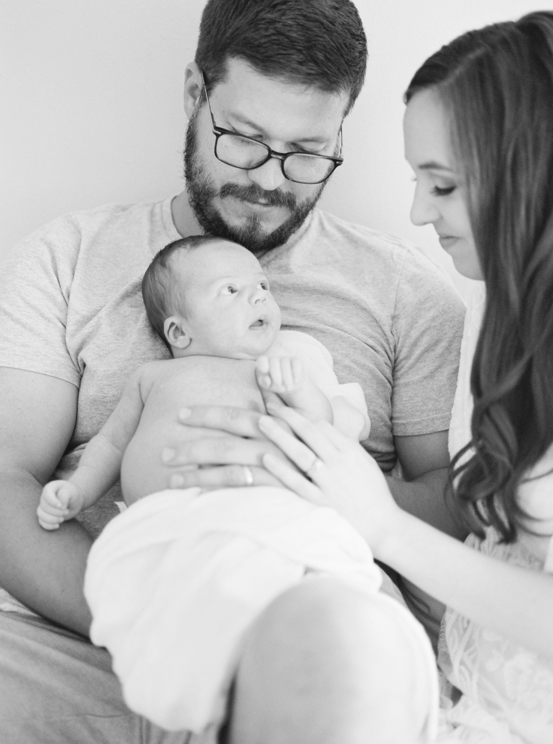 new parents admire baby boy during Charlotte newborn session