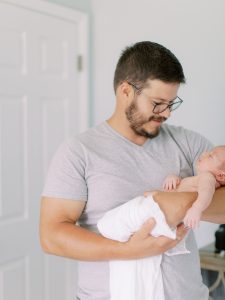 dad looks down at son during lifestyle newborn session