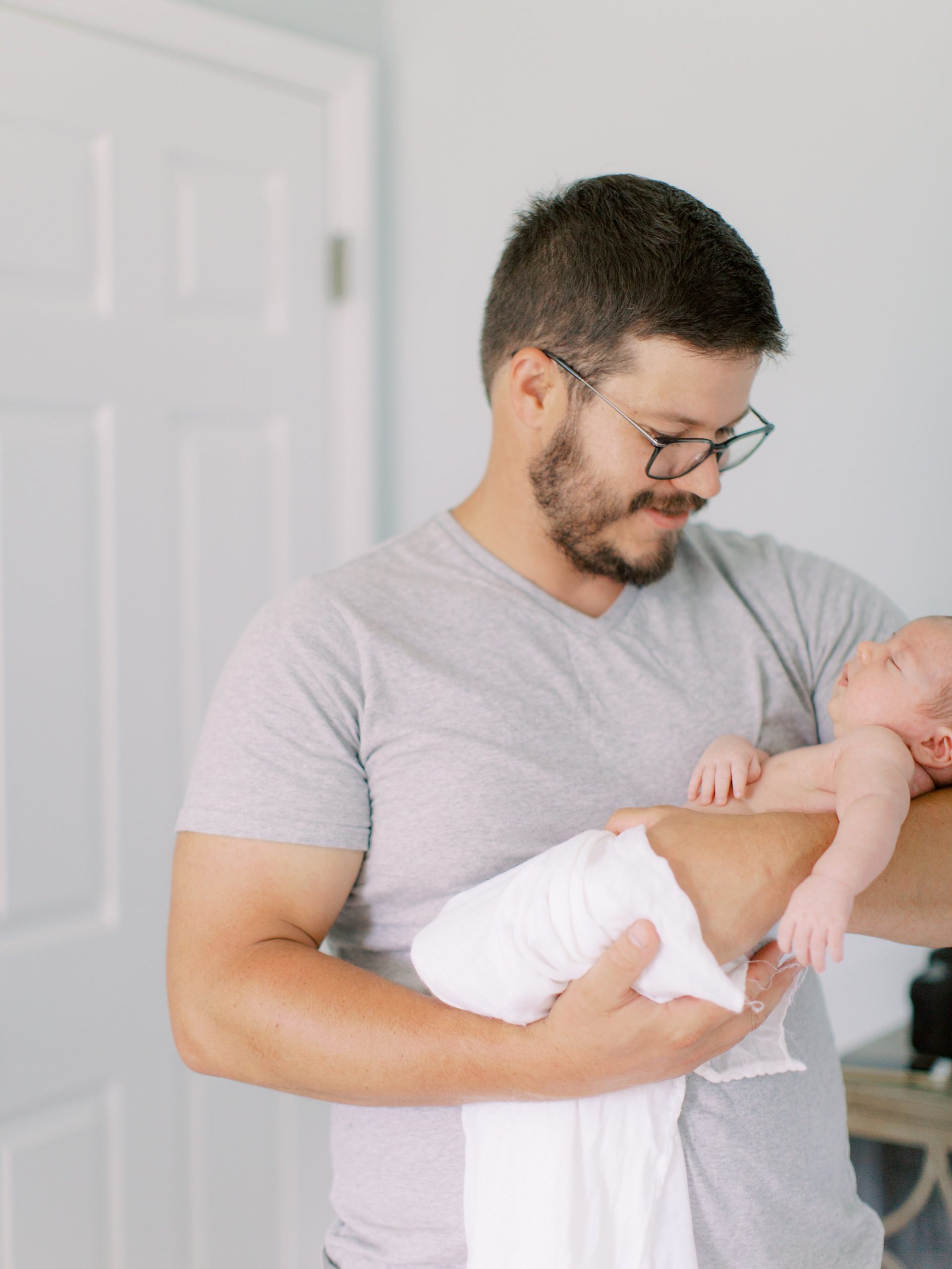 dad looks down at son during lifestyle newborn session