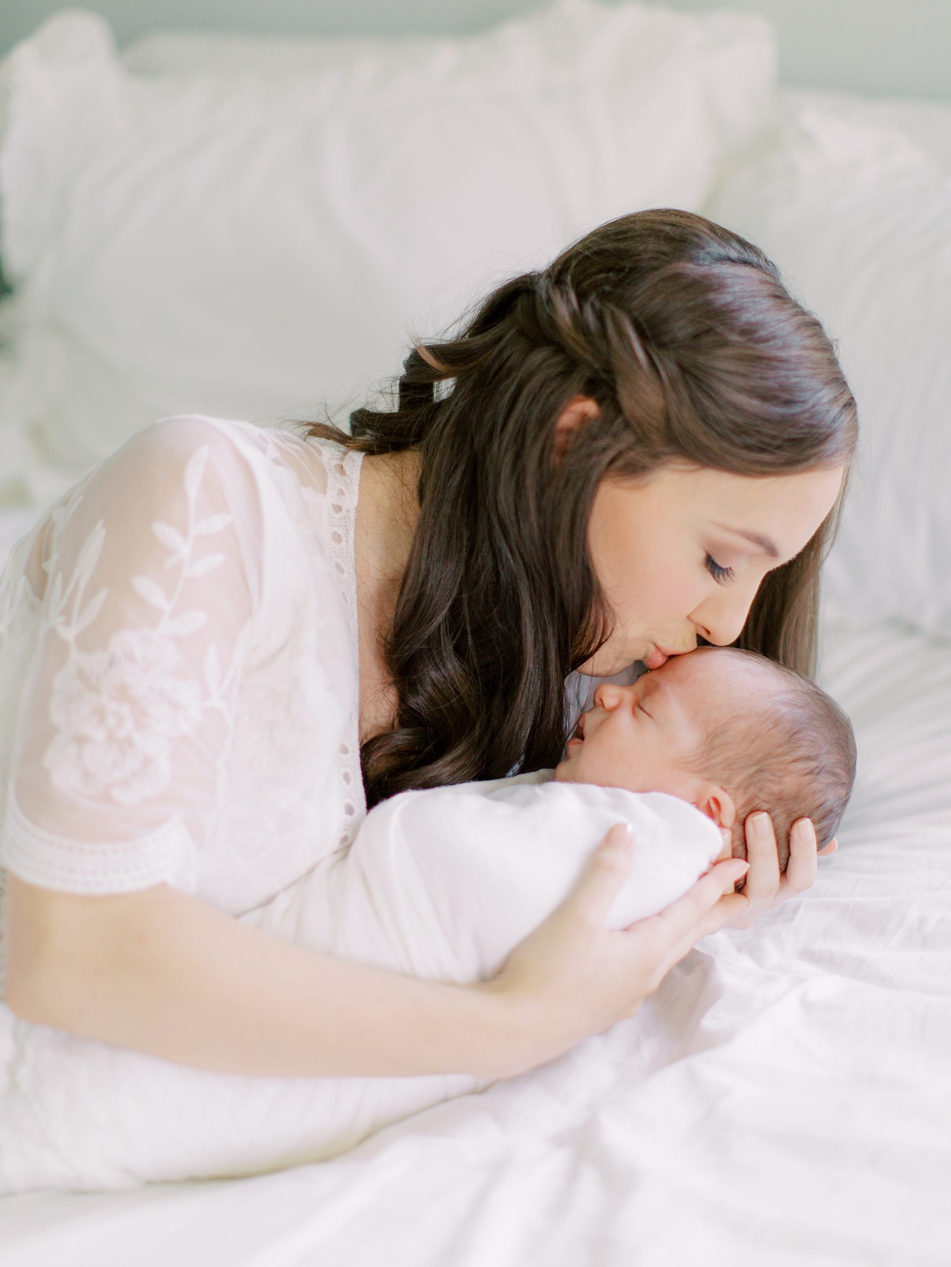mom kisses baby boy during Charlotte newborn session