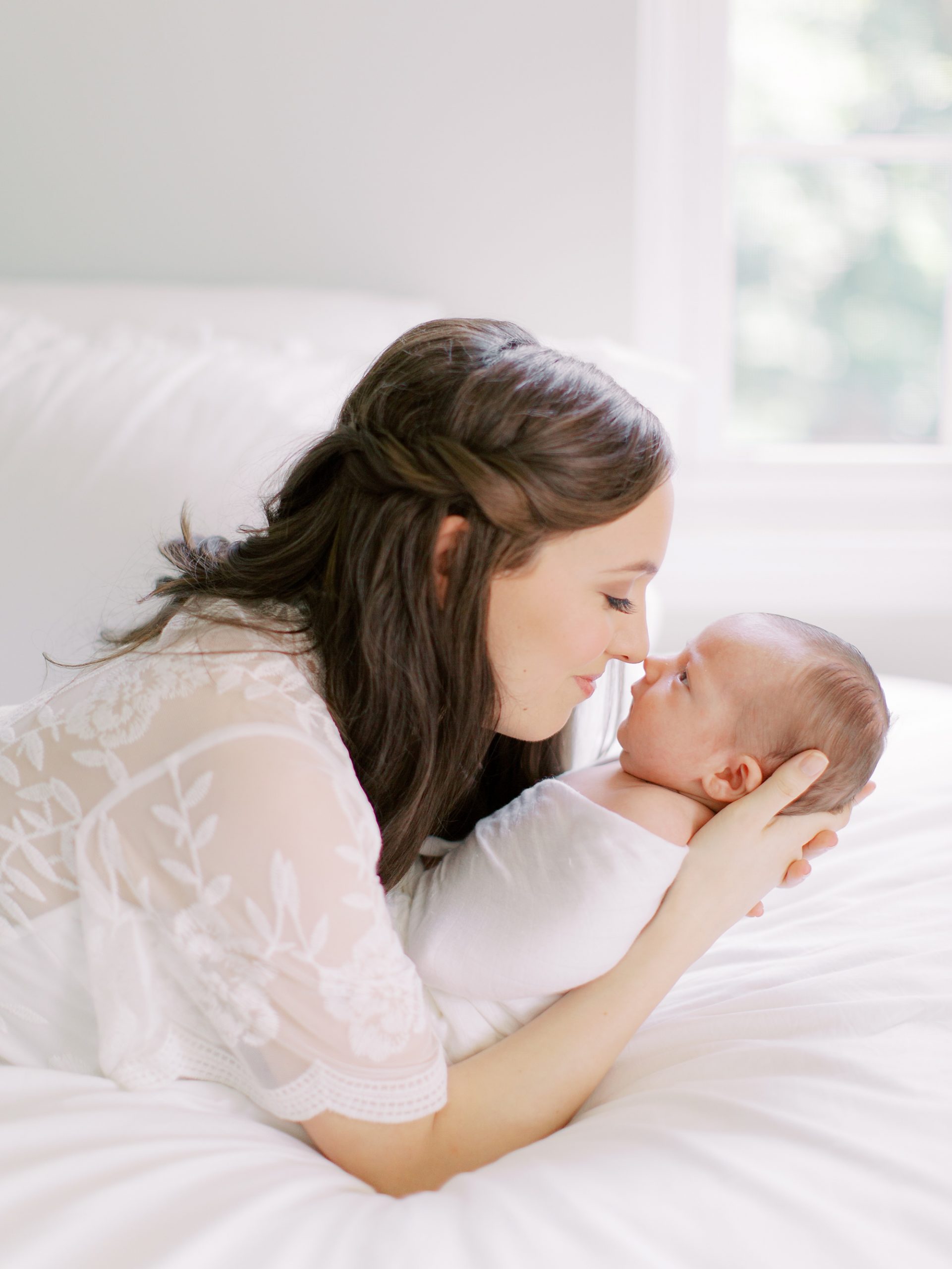 mom nuzzles noses with baby boy at home