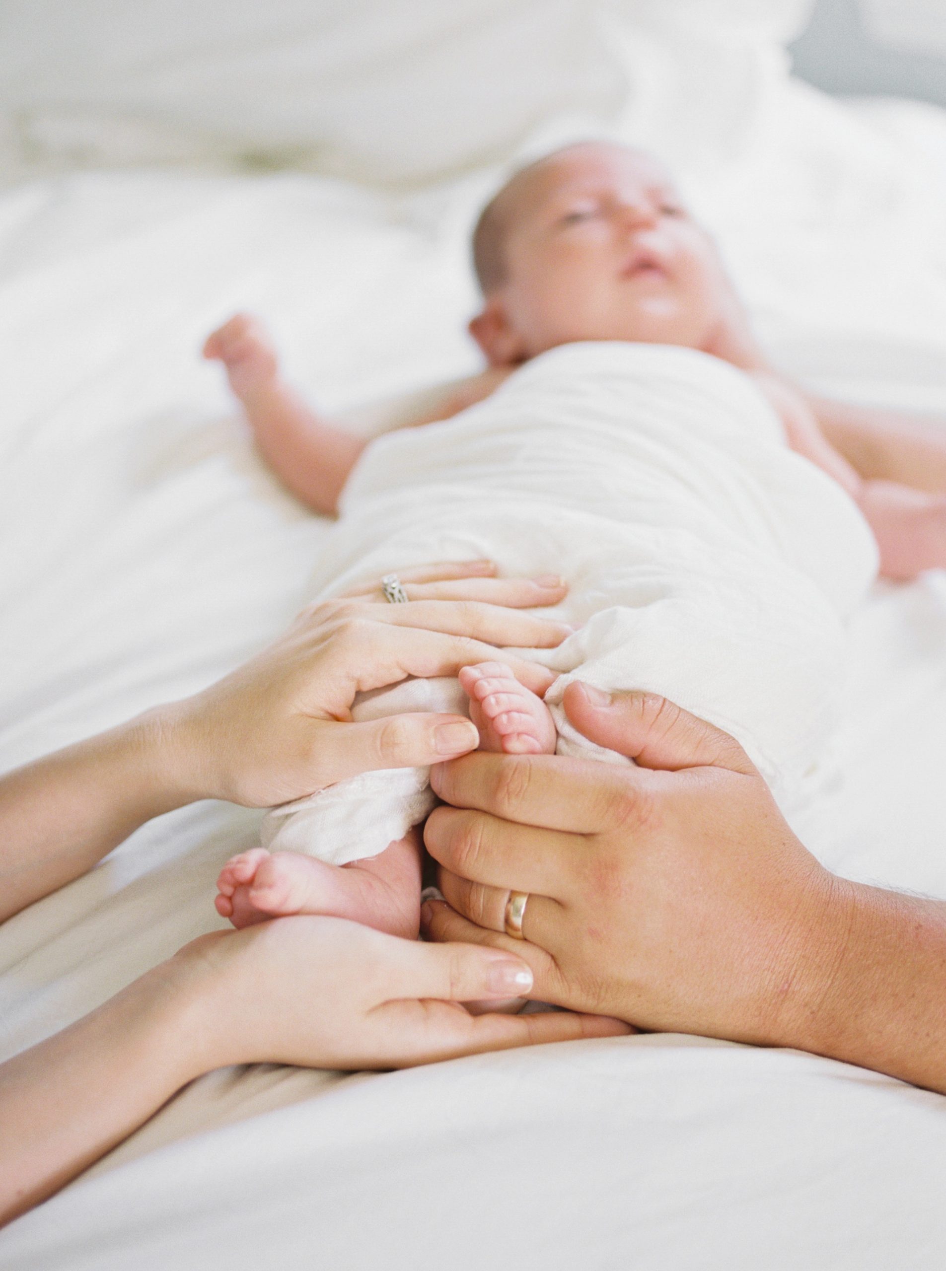 parents hold baby's feet during Charlotte newborn session