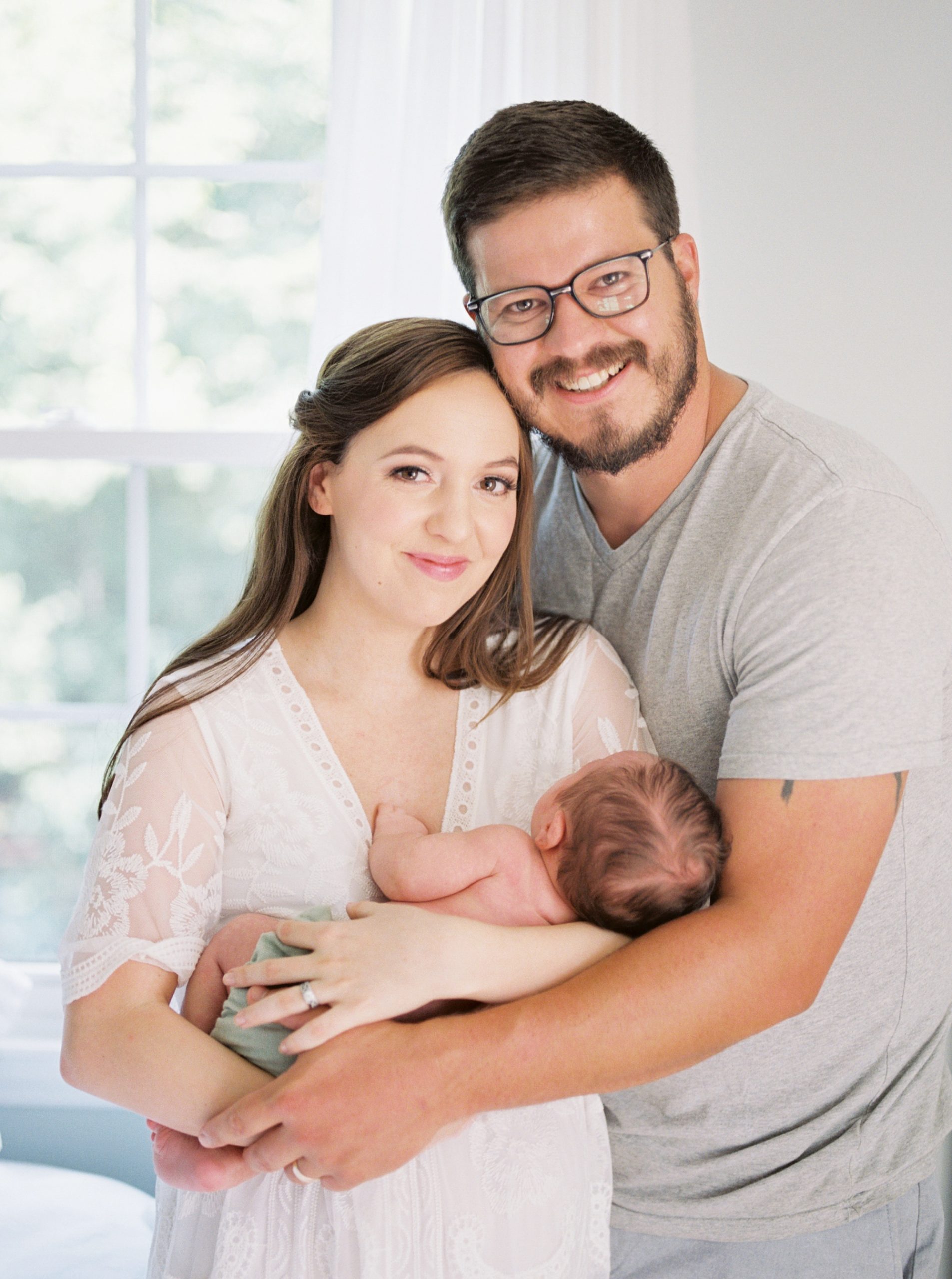 new parents hold baby boy during lifestyle session at home