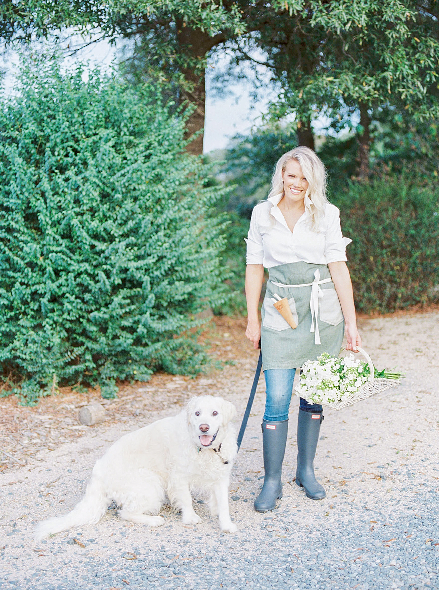 Charlotte florist Darling Dogwood Floral poses with dog by bush at Morning Glory Farm