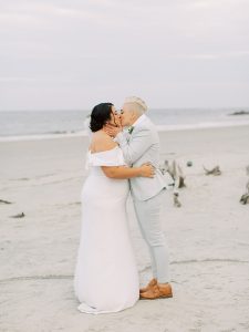 partners kiss during wedding ceremony on the beach