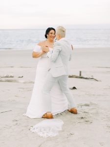 couple dances on beach after wedding ceremony