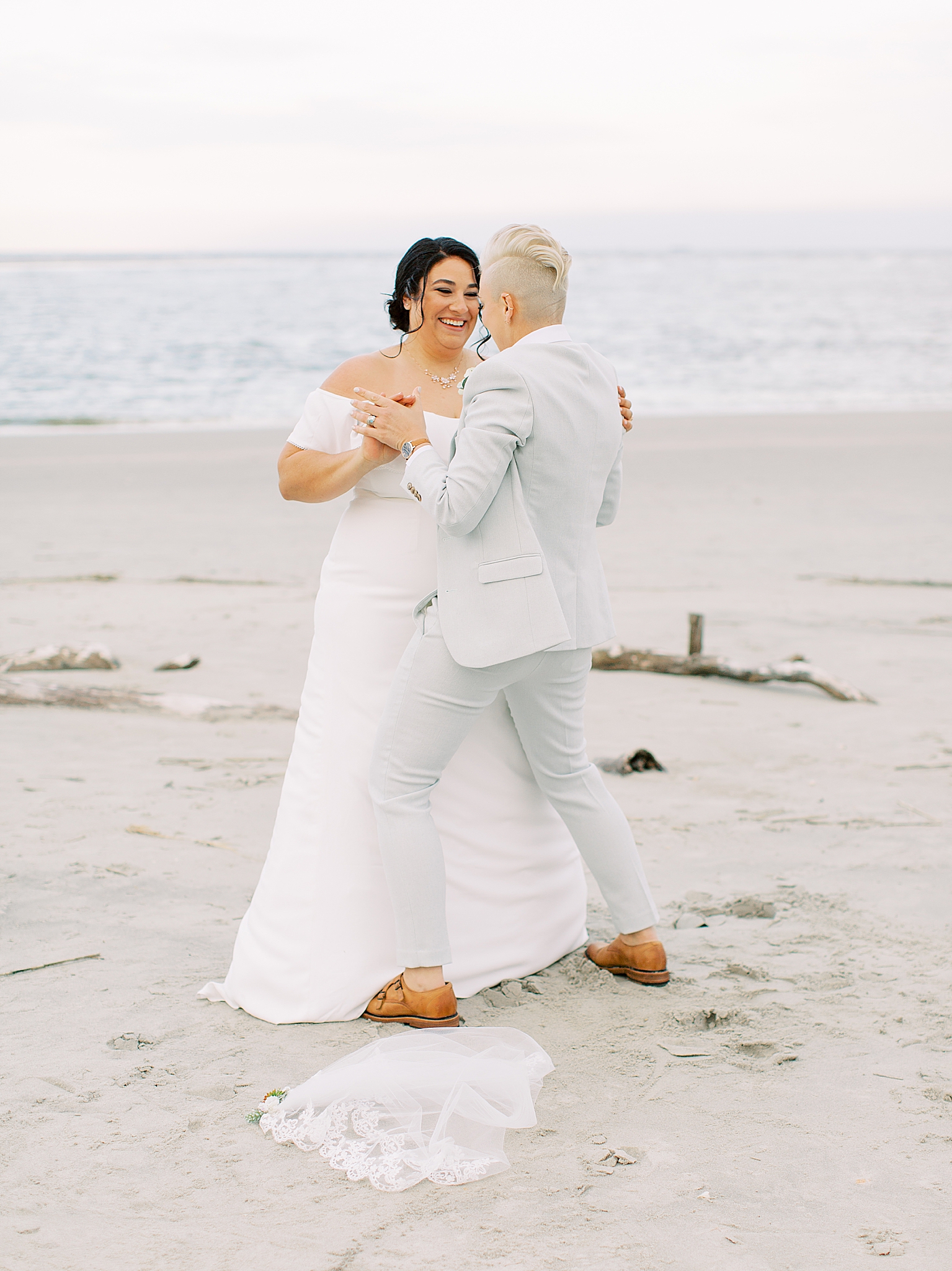 couple dances on beach after wedding ceremony