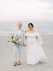 couple walks along beach during Charleston wedding photos