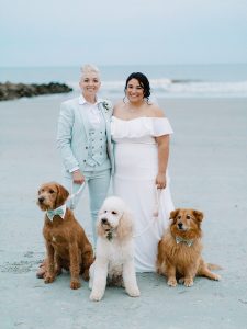 newlyweds pose with three dogs on Charleston beach