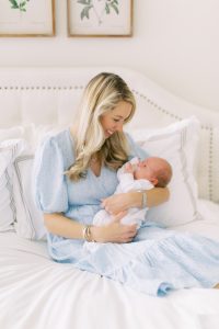 mom holds new son in bed during lifestyle newborn session
