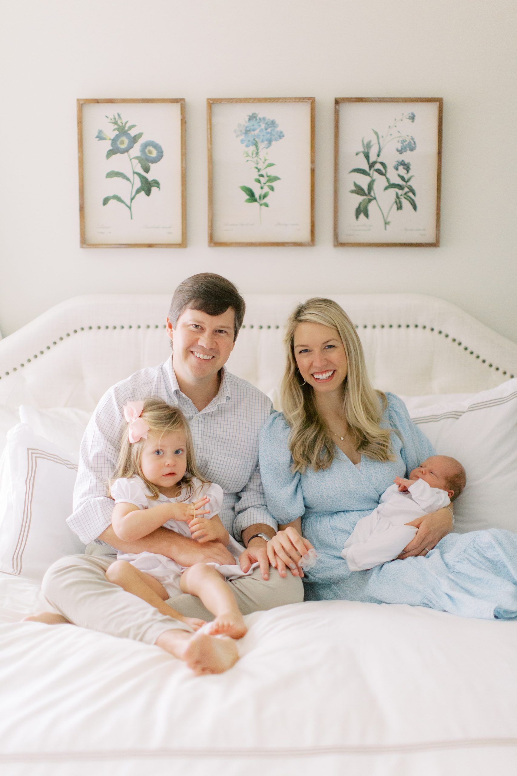 parents hold children on bed during Charlotte lifestyle newborn session