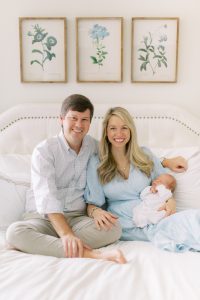 family smiles posing on bed during lifestyle photos at home