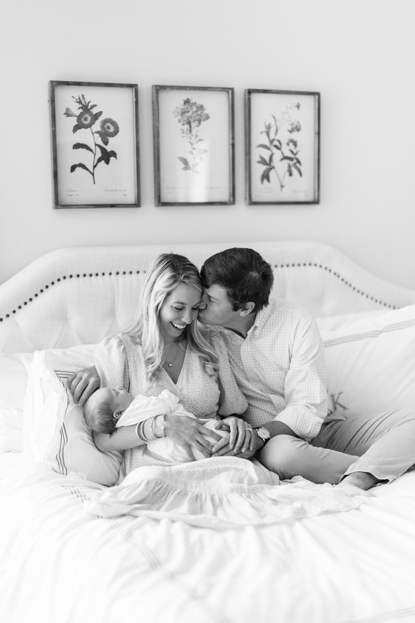 dad kisses wife during Charlotte lifestyle newborn session