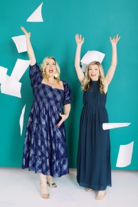 McLean Events planners toss papers in air by green wall