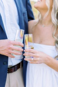 couple toasts champagne during Midtown Park engagement session
