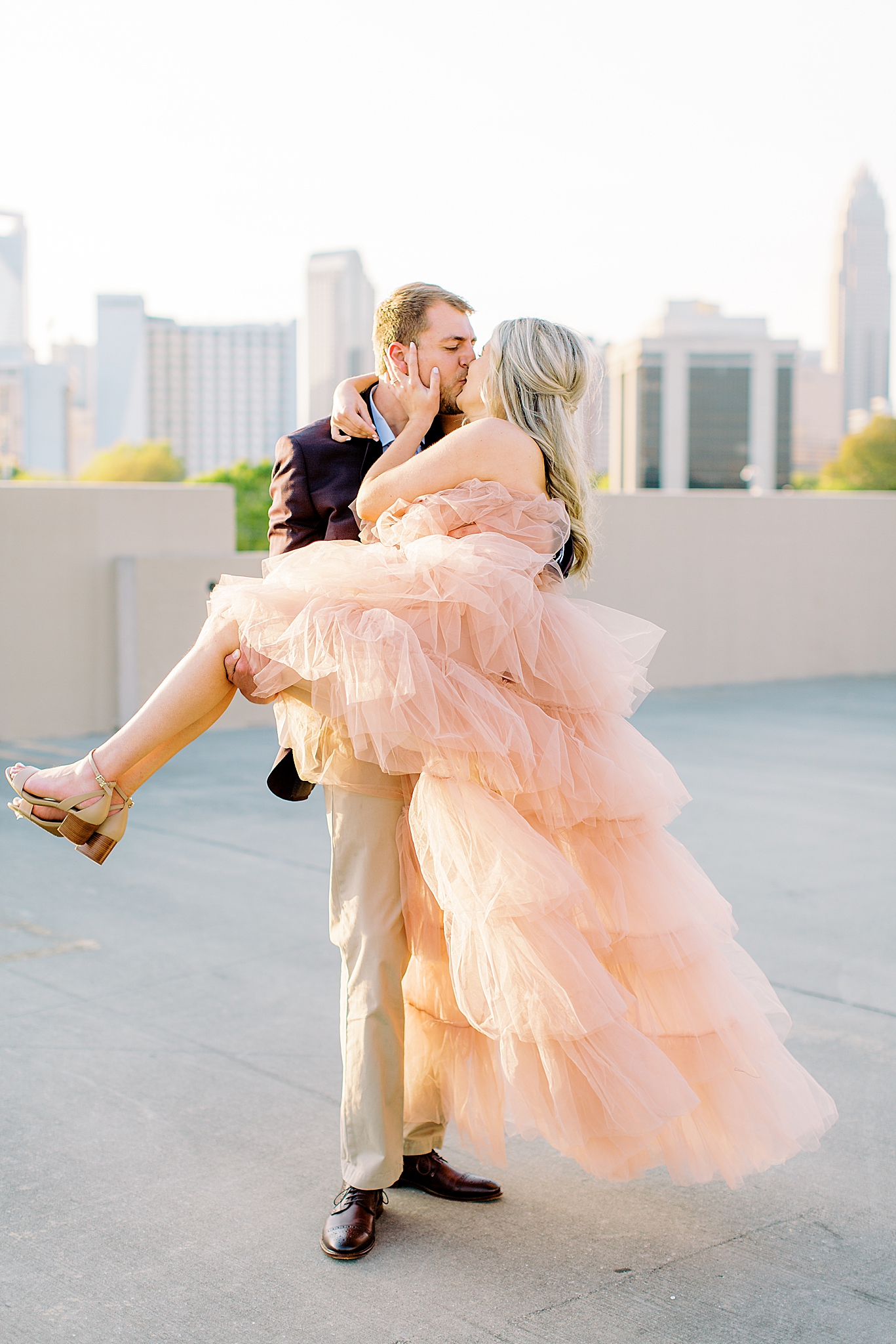 bride and groom stand on rooftop during sunset Midtown Park engagement session