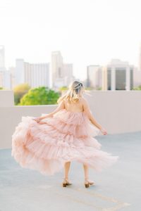 bride twirls in Untamed Petals dress on rooftop in Charlotte NC