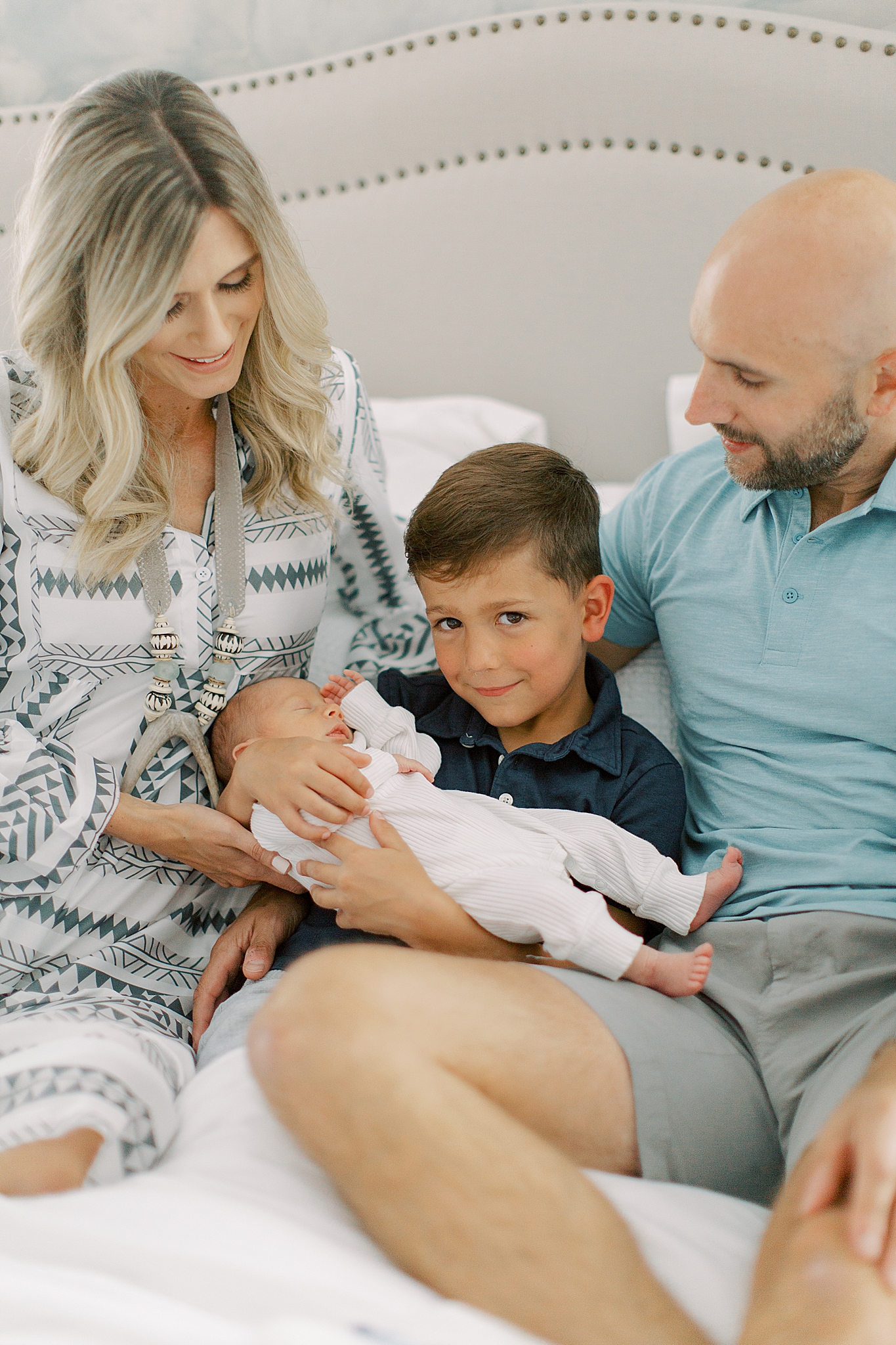 big brother holds newborn during photos at home