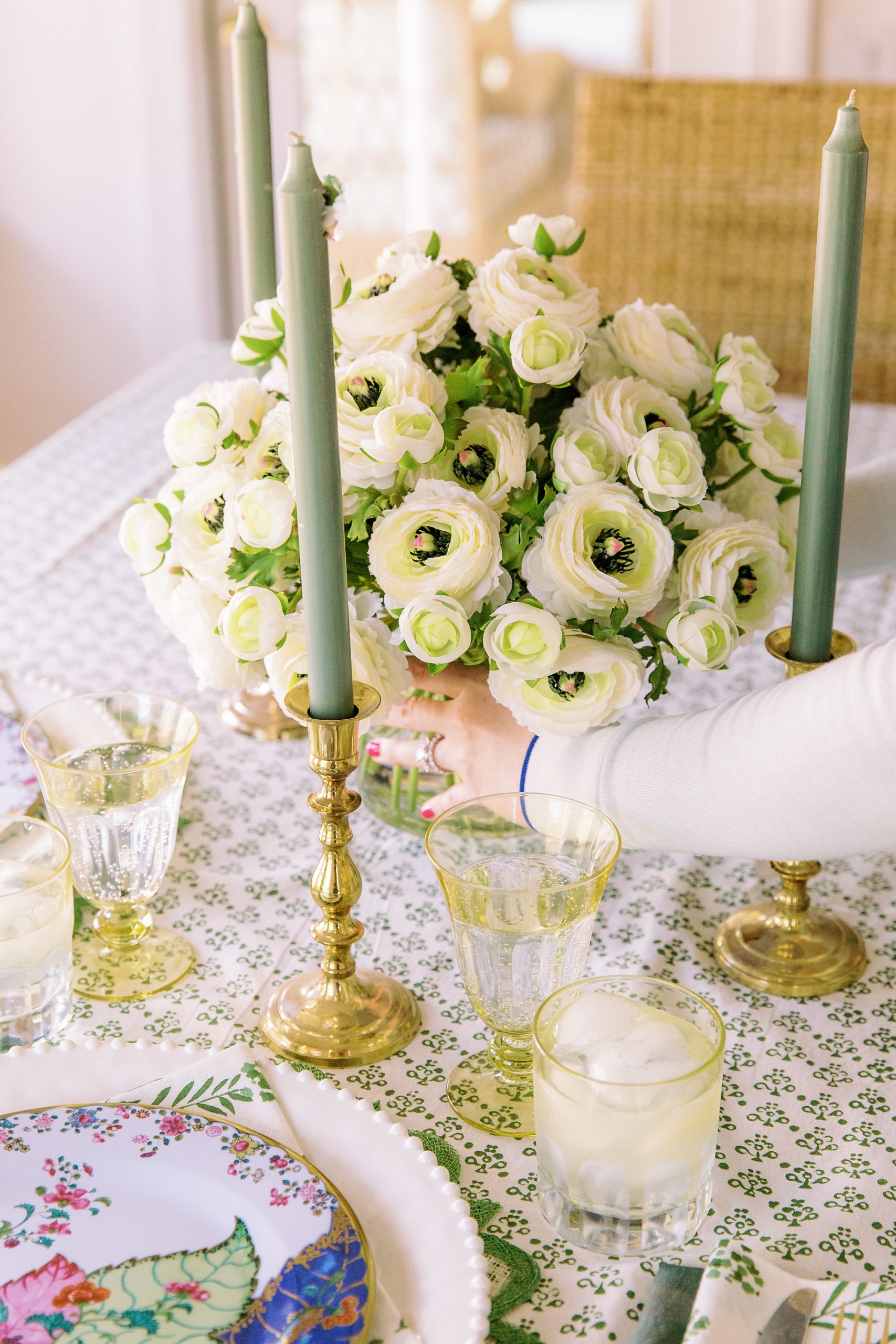 woman adjusts green pillar candles during photo session