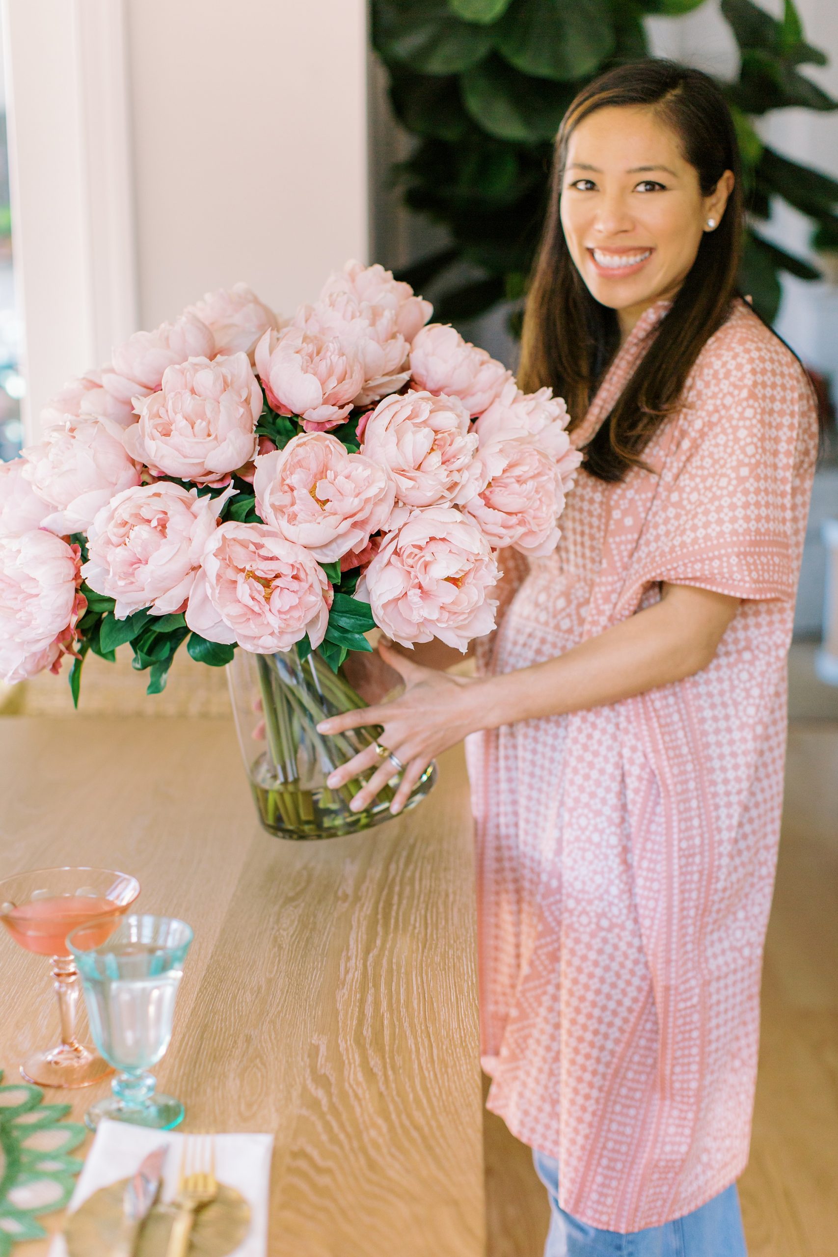 woman carries pink peonies during Charlotte product photography session