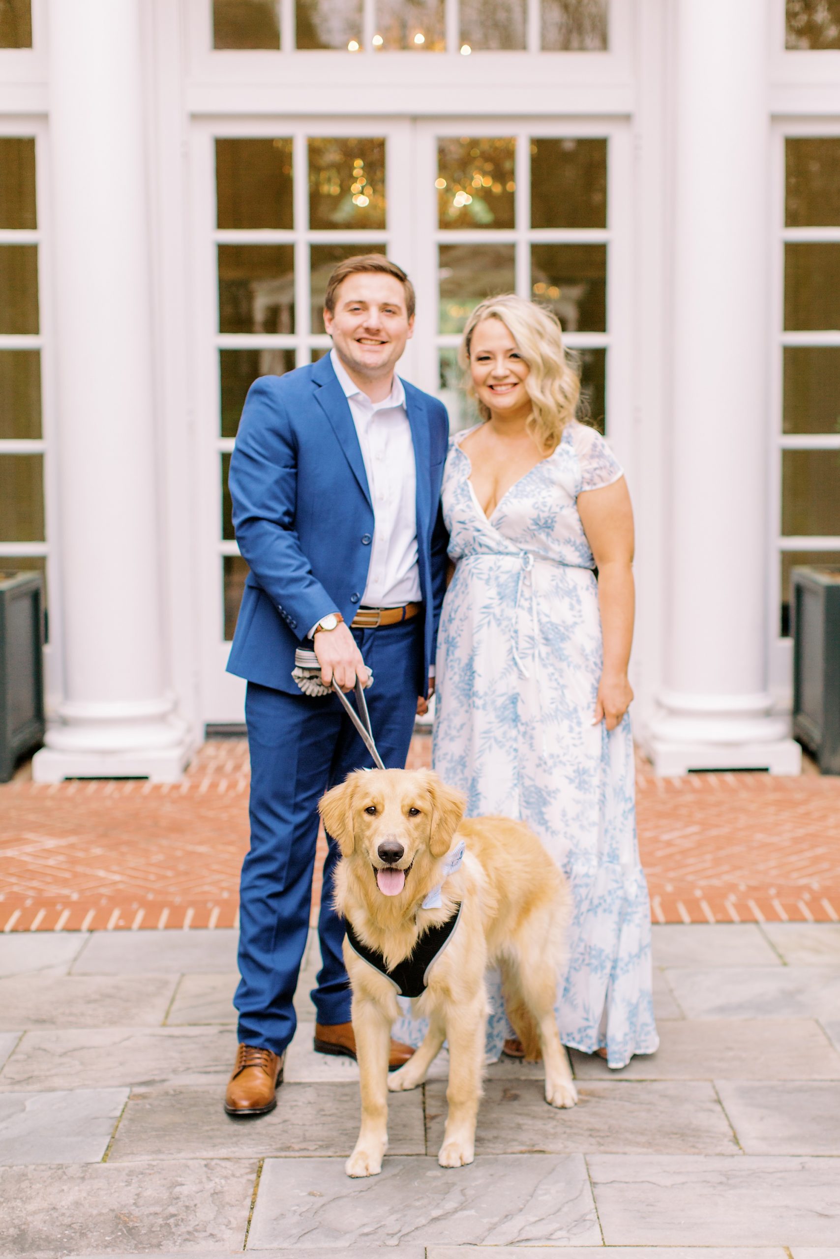 couple poses with dog outside Duke Mansion