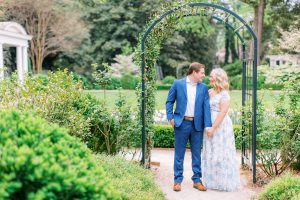 bride and groom pose by arbor at Duke Mansion