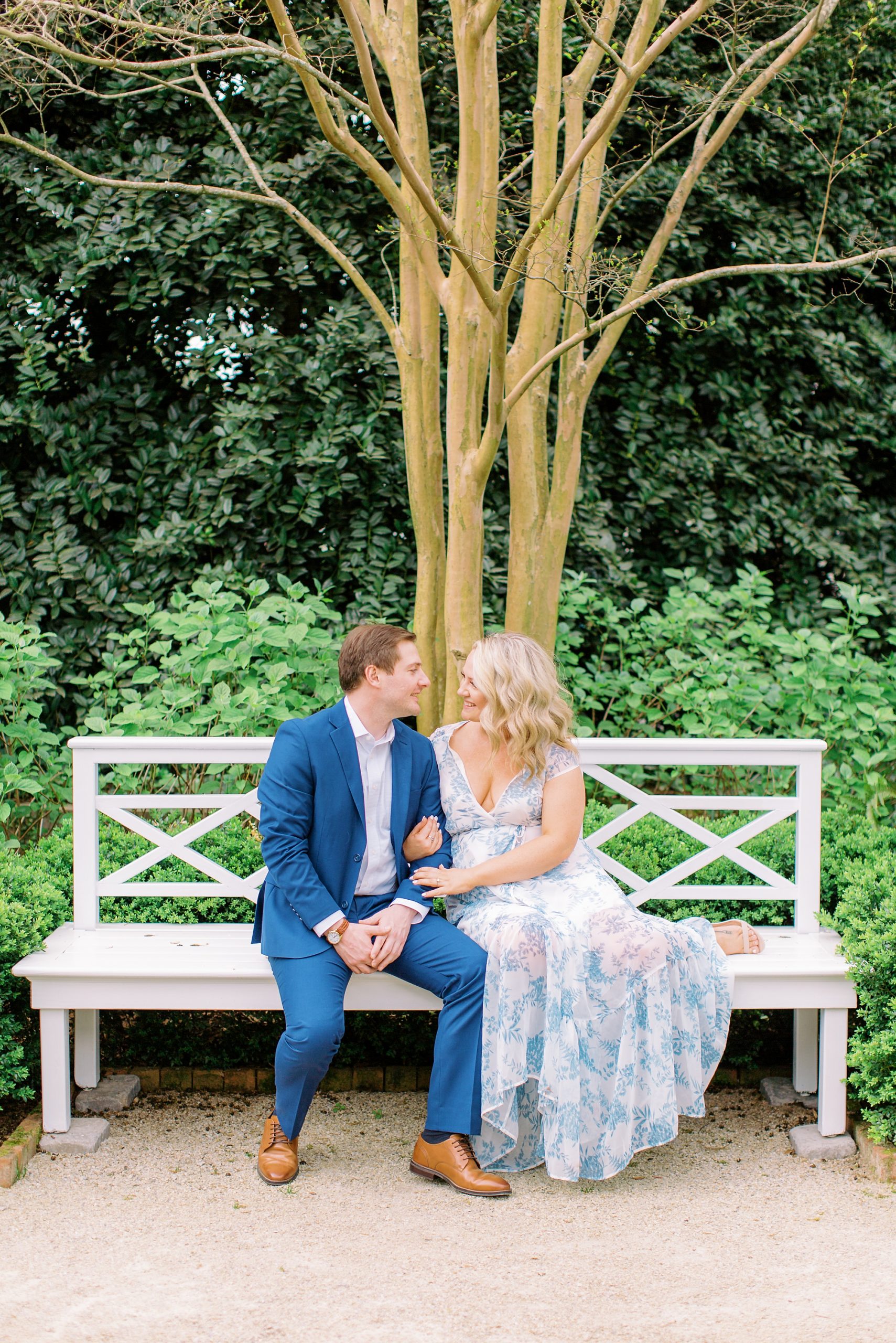 engaged couple sits on bench together at Duke Mansion