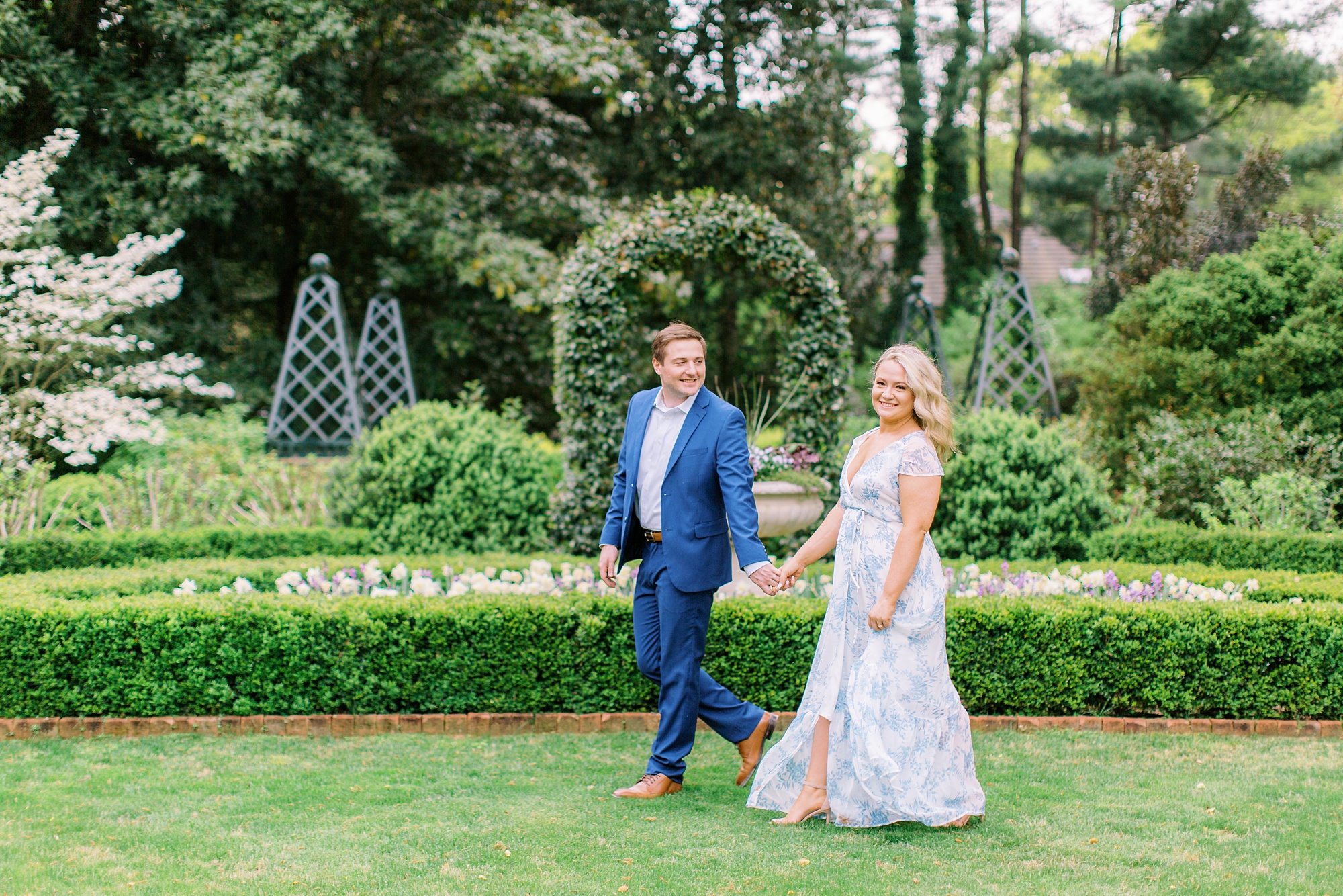 bride and groom walk through gardens in Charlotte NC