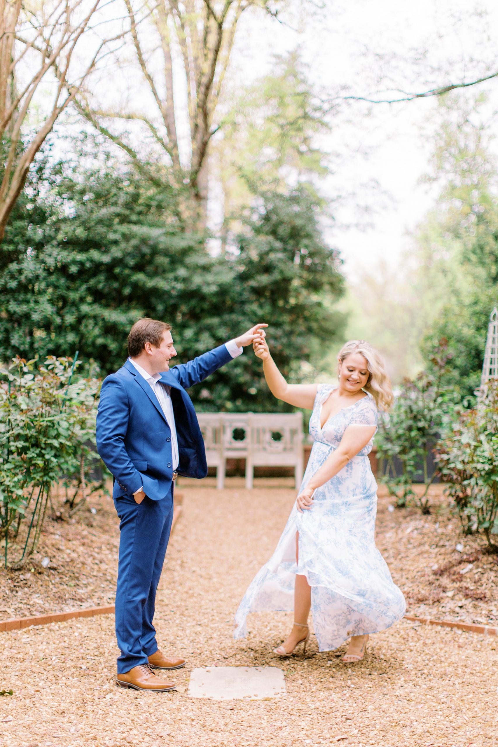 groom twirls bride during Duke Mansion engagement portraits