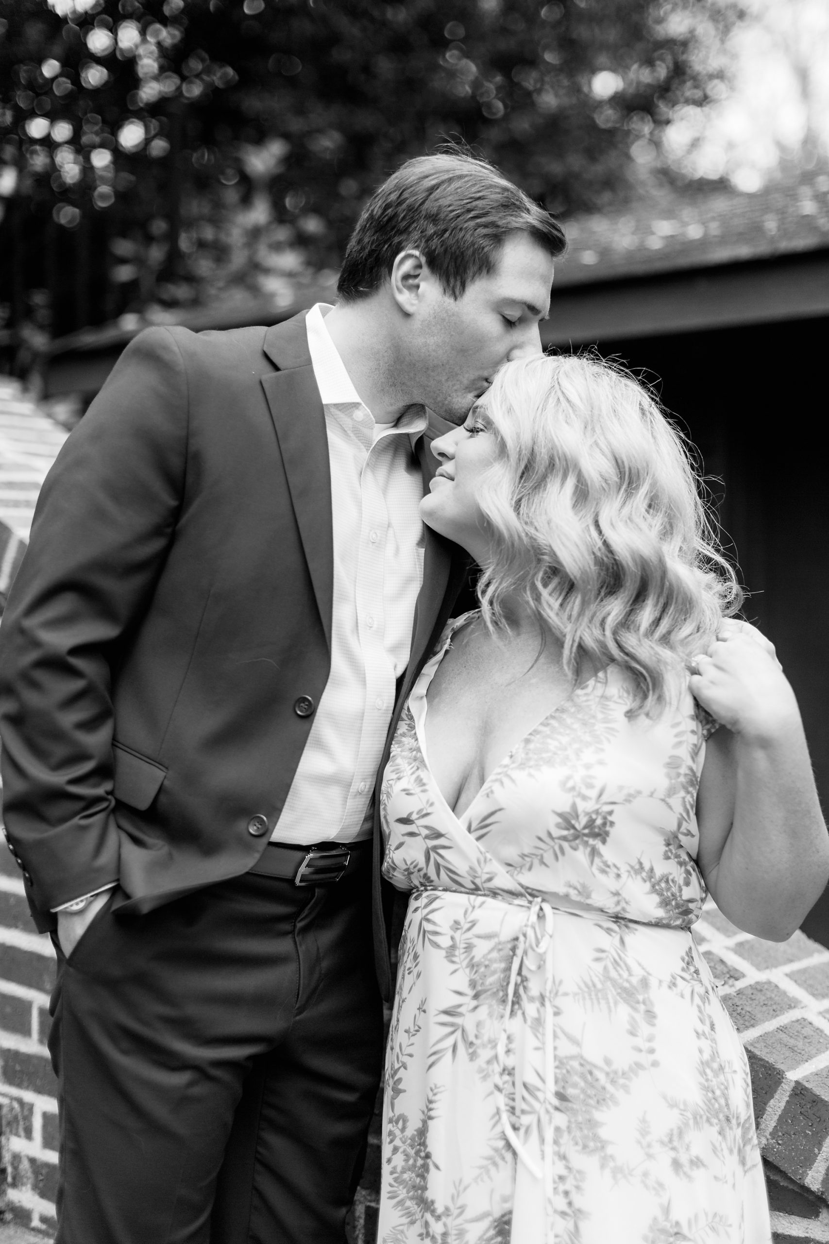 groom kisses bride's forehead during Duke Mansion engagement portraits